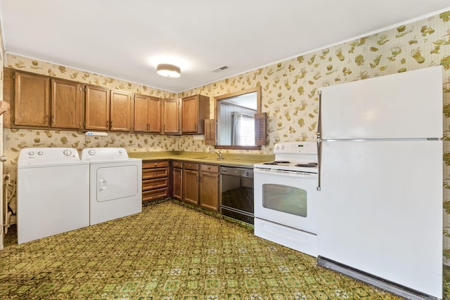 interior space with laundry area, visible vents, a sink, wallpapered walls, and washing machine and dryer