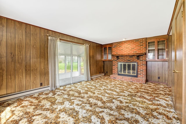 unfurnished living room with wood walls, carpet flooring, a fireplace, and baseboard heating