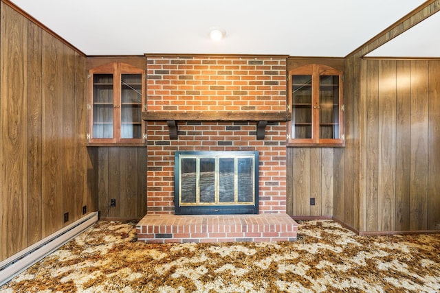 unfurnished living room featuring wood walls, a baseboard heating unit, and a brick fireplace