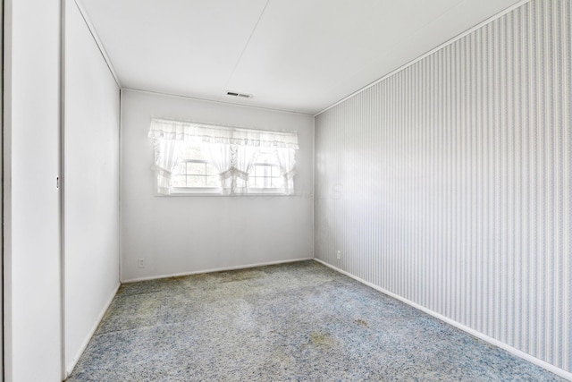 carpeted spare room featuring visible vents