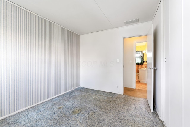carpeted spare room featuring visible vents