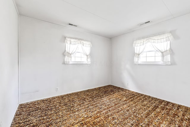 spare room featuring a wealth of natural light and visible vents