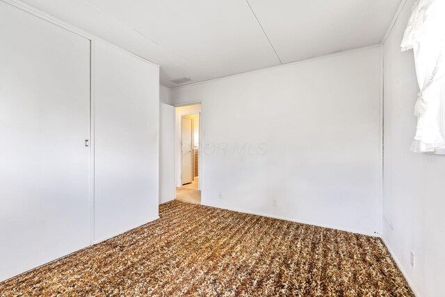 unfurnished bedroom featuring carpet flooring and ornamental molding