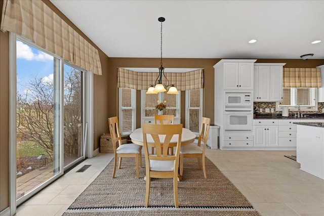 dining space with an inviting chandelier, light tile patterned floors, visible vents, and recessed lighting