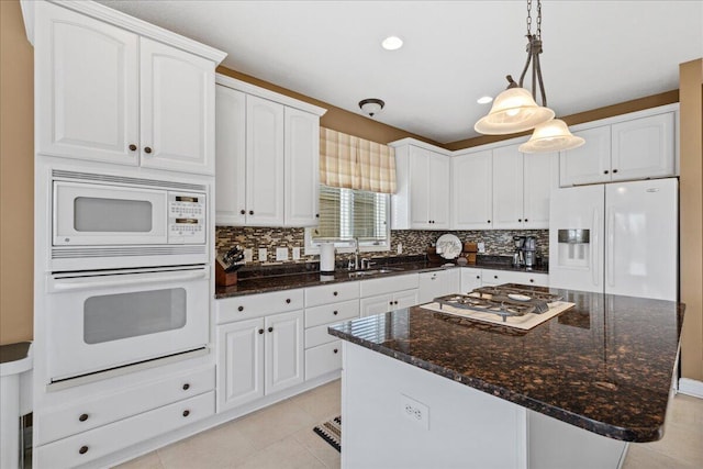 kitchen featuring decorative backsplash, white appliances, white cabinets, and light tile patterned floors