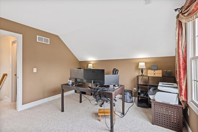 carpeted office space featuring visible vents, baseboards, plenty of natural light, and vaulted ceiling