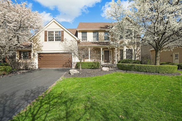 traditional home with a front yard, an attached garage, stone siding, and driveway