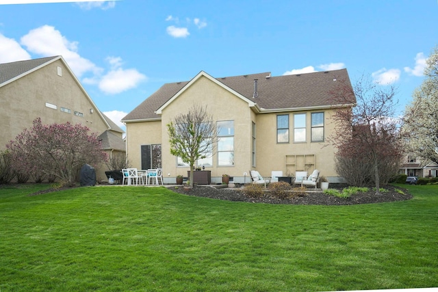 rear view of property with a patio, stucco siding, and a lawn