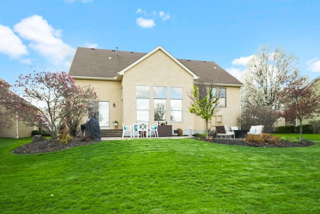 rear view of house featuring a patio area, stucco siding, and a lawn