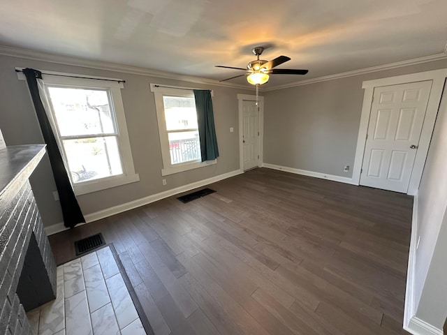 interior space featuring crown molding, baseboards, ceiling fan, and visible vents
