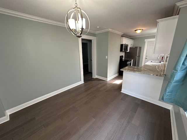 kitchen featuring white cabinetry, ornamental molding, stainless steel appliances, dark wood finished floors, and light stone counters