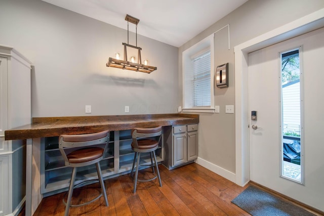 62 Sherman Ave, Columbus, OH 43205 - dining area featuring dark wood finished floors, baseboards, and a bar