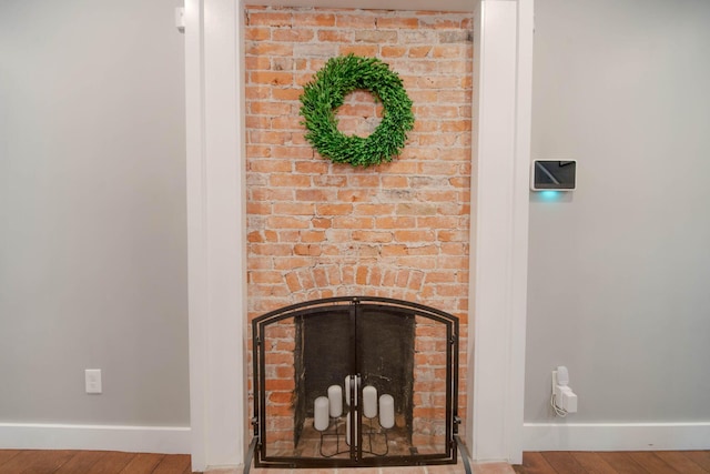 62 Sherman Ave, Columbus, OH 43205 - detailed view of baseboards, wood finished floors, and a brick fireplace
