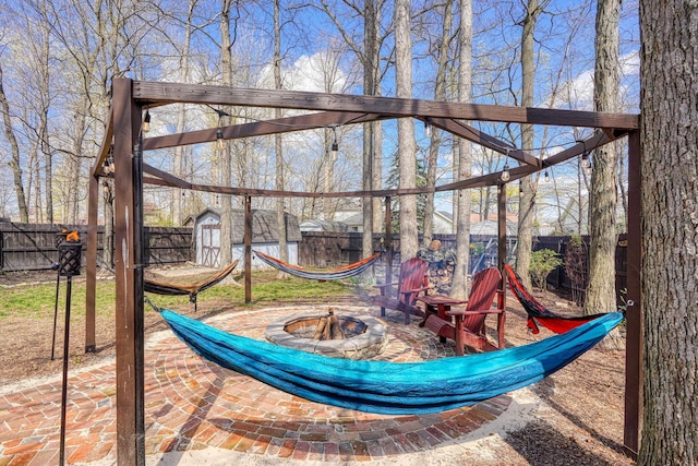exterior space featuring a fenced backyard, an outdoor structure, and an outdoor fire pit