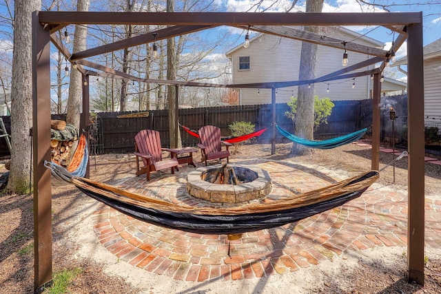 view of patio featuring a fenced backyard, a pergola, and a fire pit