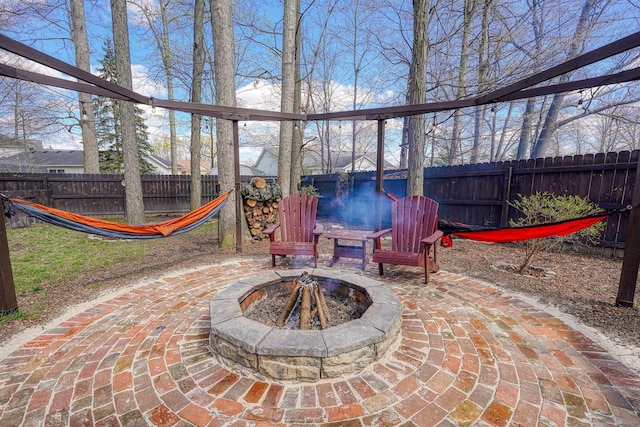 view of patio featuring a fenced backyard and a fire pit