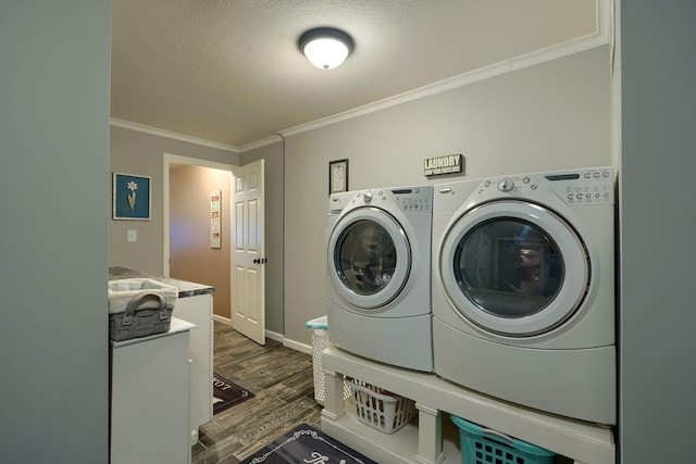 clothes washing area featuring laundry area, a textured ceiling, ornamental molding, washer and dryer, and dark wood-style floors