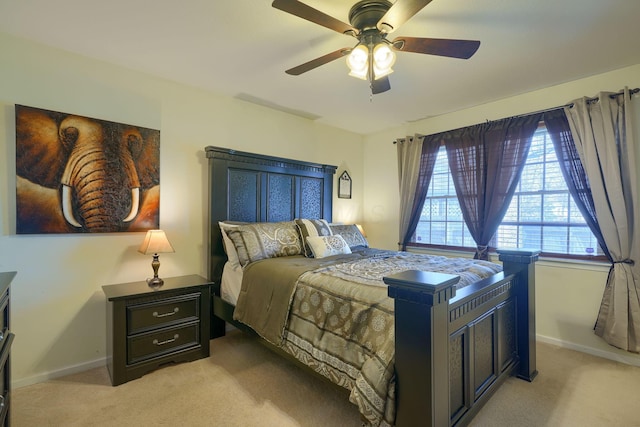 bedroom with light colored carpet, baseboards, and a ceiling fan