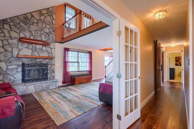 living room featuring baseboards, stairway, wood finished floors, and a fireplace