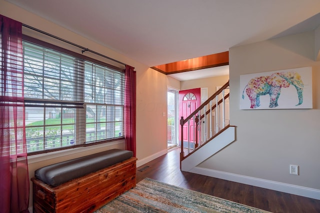 foyer with baseboards, dark wood-style floors, plenty of natural light, and stairs