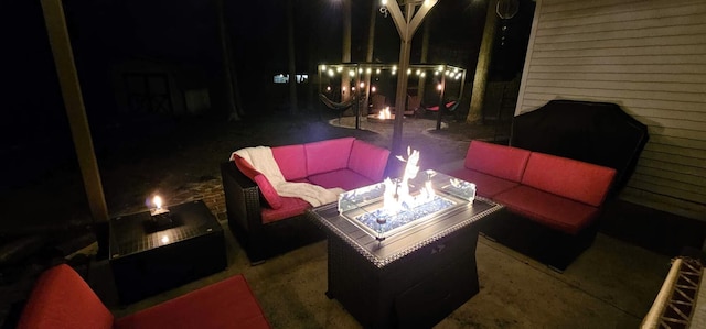 patio at night with an outdoor living space with a fire pit
