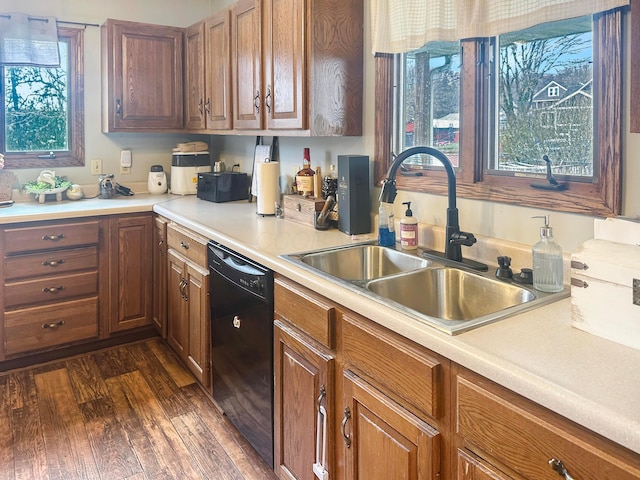 113 Chestnut St SE, Corning, OH 43730 - kitchen with light countertops, dark wood-type flooring, a sink, black dishwasher, and brown cabinetry