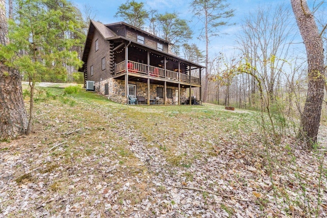26063 Twin Fls, Rockbridge, OH 43149 - rear view of house with stone siding, central AC unit, log exterior, a deck, and a yard