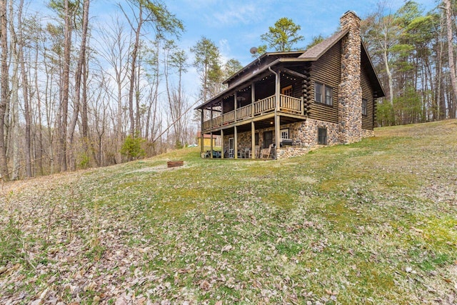 26063 Twin Fls, Rockbridge, OH 43149 - rear view of house with a wooden deck, a lawn, stone siding, log exterior, and a chimney