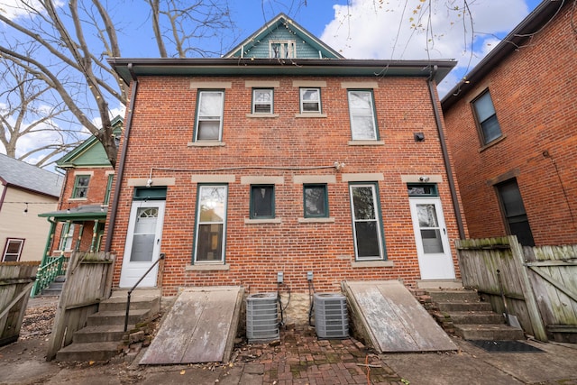 69-71 E 1st Ave, Columbus, OH 43201 - back of house featuring brick siding, central AC unit, entry steps, and fence