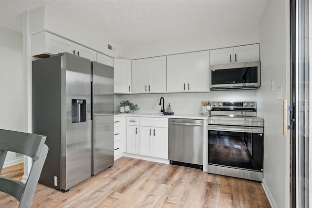 5696 Great Hall Ct, Columbus, OH 43231 - kitchen with light countertops, visible vents, light wood finished floors, appliances with stainless steel finishes, and a sink