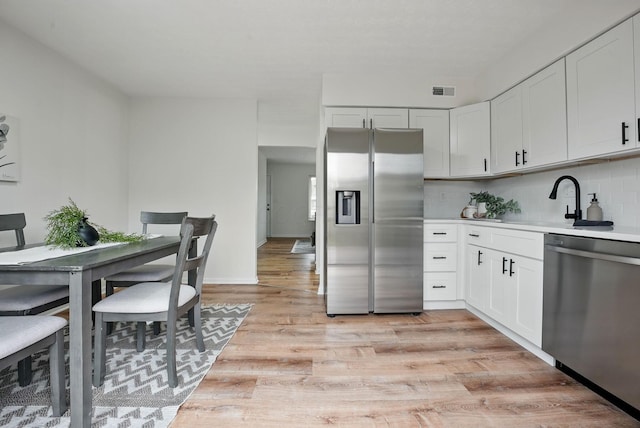 5696 Great Hall Ct, Columbus, OH 43231 - kitchen featuring backsplash, a sink, light wood-type flooring, stainless steel appliances, and visible vents