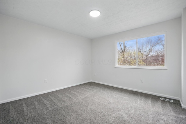 5696 Great Hall Ct, Columbus, OH 43231 - spare room with baseboards, visible vents, a textured ceiling, and dark carpet