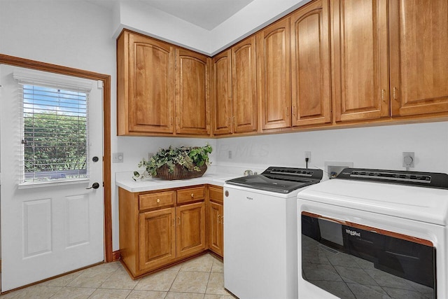 laundry room featuring light tile patterned flooring, washing machine and clothes dryer, and cabinet space