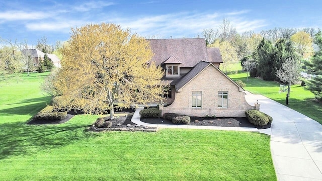 view of front of home featuring a front lawn and brick siding