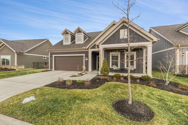 view of front of property featuring fence, a garage, concrete driveway, a front lawn, and covered porch