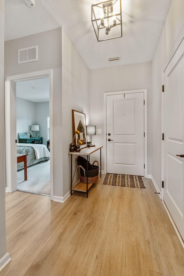 entrance foyer with baseboards, visible vents, and wood finished floors