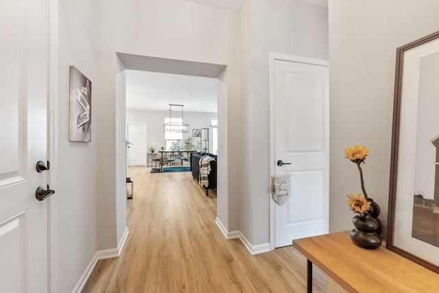hall with baseboards and light wood-type flooring