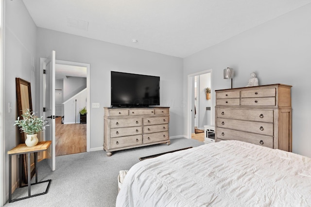 bedroom featuring light carpet and baseboards
