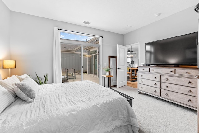 bedroom with access to exterior, visible vents, and light carpet