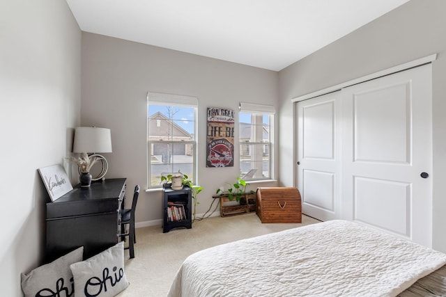 carpeted bedroom featuring baseboards and a closet