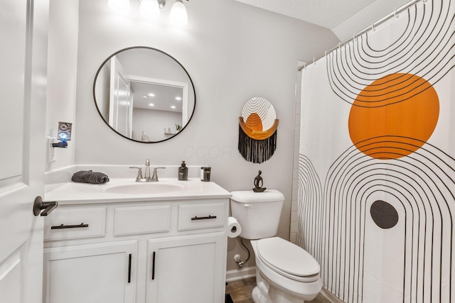 bathroom featuring toilet, vanity, and a shower with curtain