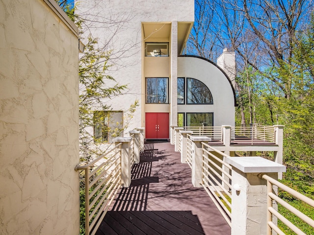 entrance to property with a chimney and stucco siding