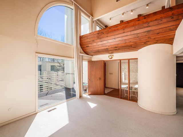 interior space with visible vents, high vaulted ceiling, carpet flooring, and track lighting