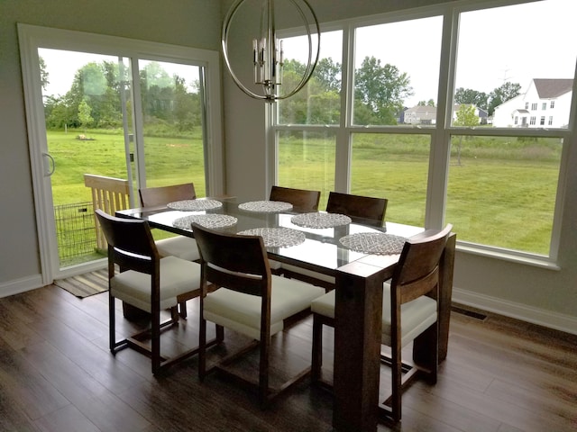 sunroom with a wealth of natural light, a notable chandelier, and visible vents