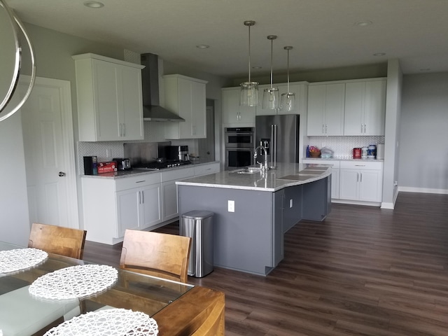 kitchen with white cabinetry, wall chimney exhaust hood, and appliances with stainless steel finishes