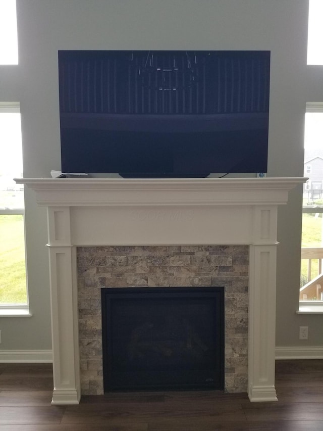 interior details featuring baseboards, a fireplace, and wood finished floors