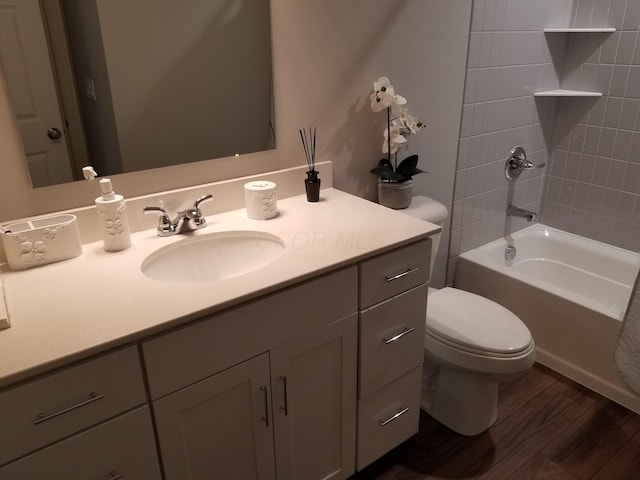 bathroom with shower / tub combination, wood finished floors, toilet, and vanity