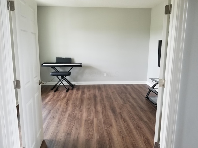 interior space featuring baseboards and wood finished floors