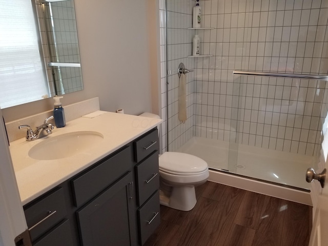 bathroom featuring vanity, wood finished floors, toilet, and a shower stall