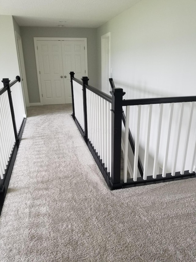 hallway featuring carpet floors and an upstairs landing